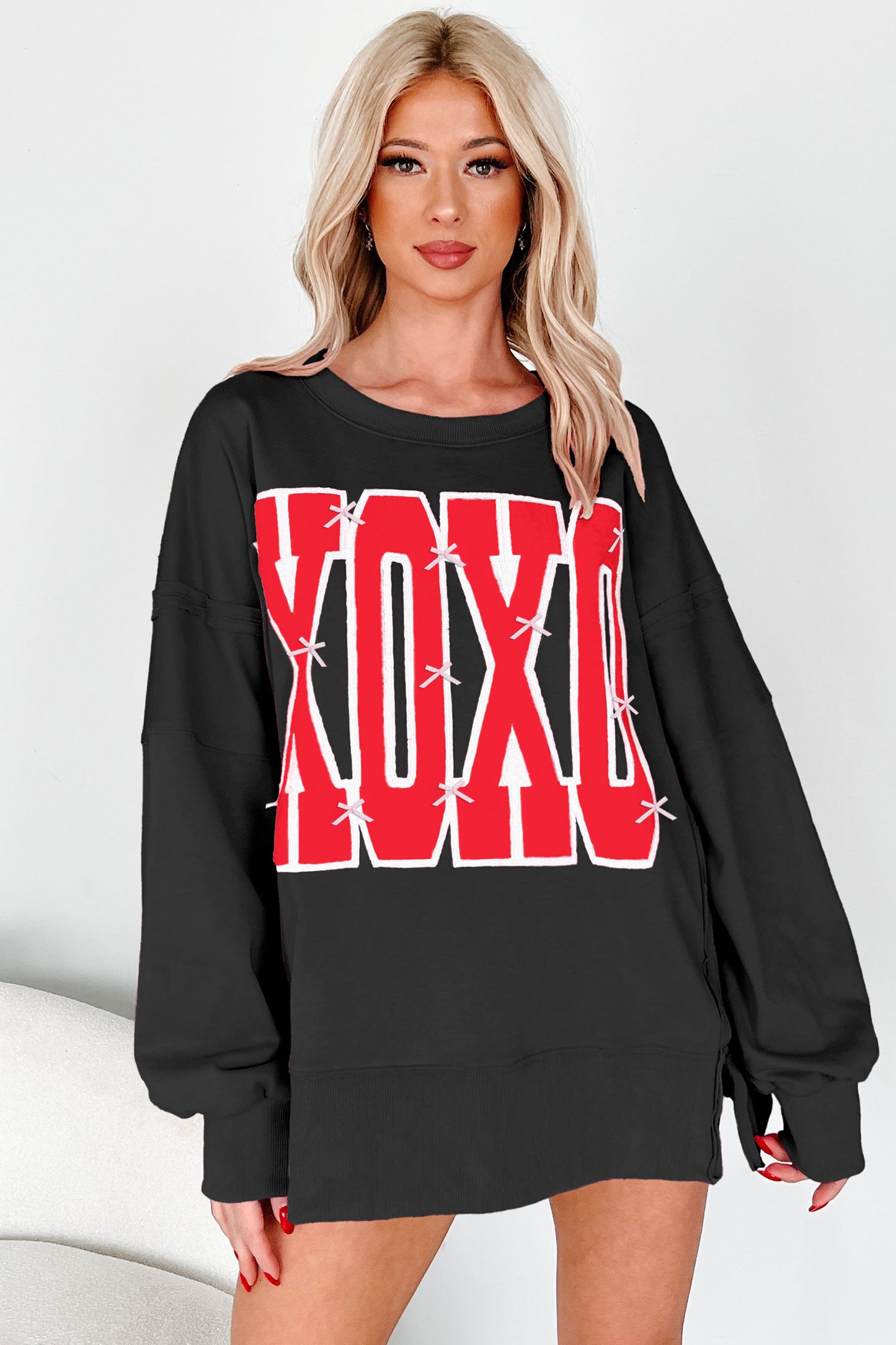 কালো বো সিকুইন XOXO লেটার গ্রাফিক এক্সপোজড সিম ব্যাগী সোয়েটশার্ট