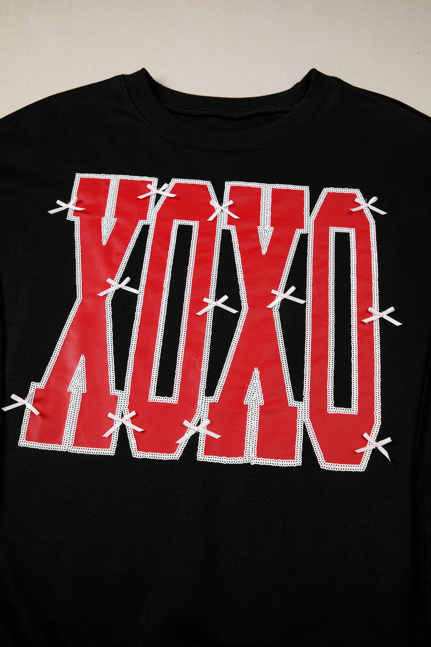 কালো বো সিকুইন XOXO লেটার গ্রাফিক এক্সপোজড সিম ব্যাগী সোয়েটশার্ট