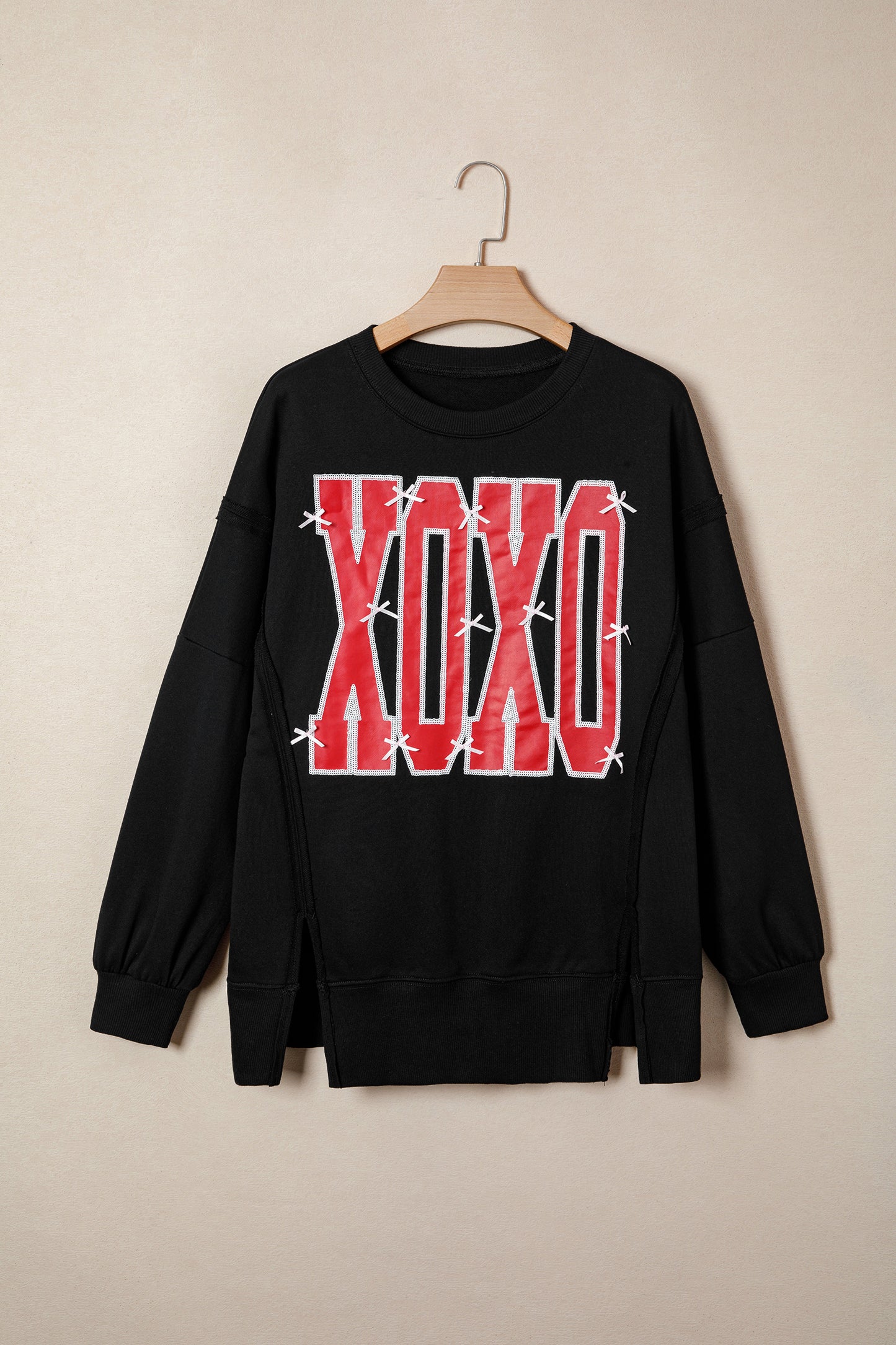 কালো বো সিকুইন XOXO লেটার গ্রাফিক এক্সপোজড সিম ব্যাগী সোয়েটশার্ট